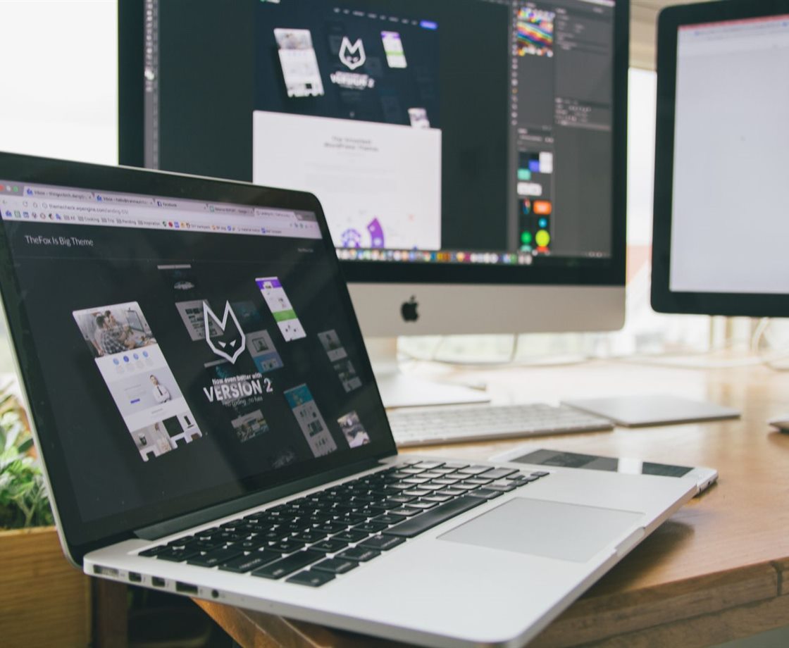 A design workspace with a laptop and monitors