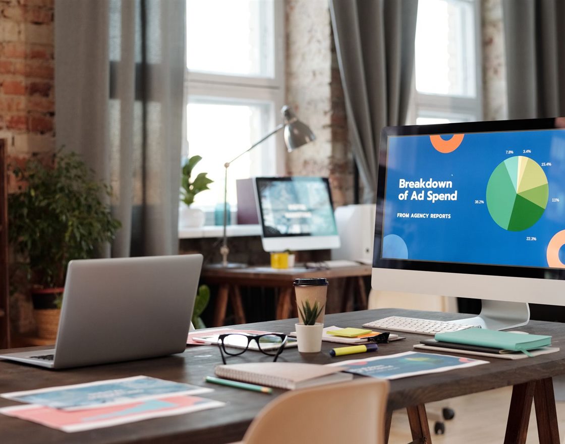 A modern office with an ad spend dashboard on screen