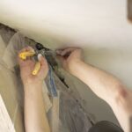 Worker fixing glass fiber mesh before plaster